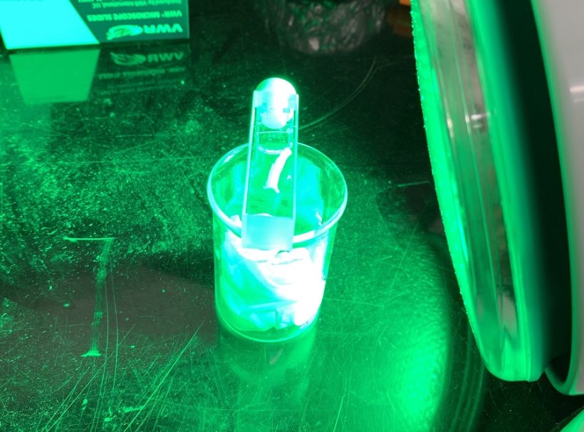 Material coated in polymer in small scale tests with a green lamp.